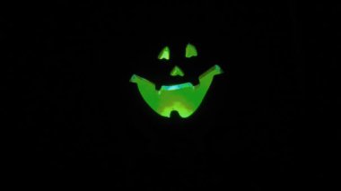 Cadılar Bayramı siyah arka planda parlayan balkabakları. Kabak kafasının içinde turuncu parlak ışık var. Koyu renk gülücük. Televizyon gürültüsü ve arıza etkisi. Balkabağı feneri. Işıldayan ve parlayan ışık