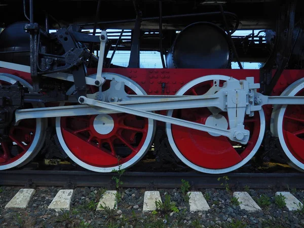Bir lokomotifin antika tekerlekleri ya da tren yakın çekim. Piston güdümlü kırmızı büyük metal tekerlekler. 19. ve 20. yüzyılların lokomotifi.. — Stok fotoğraf