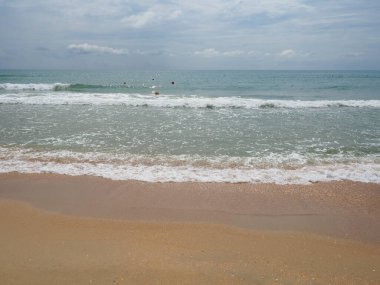 Yumuşak dalgalı, mavi gökyüzü kumlu ve serbest alanlı yaz denizi. Yumuşak mavi okyanus dalgası ya da temiz kumsalda açık deniz yaz konsepti. Muhteşem bir sahil manzarası. Deniz suyunda köpük