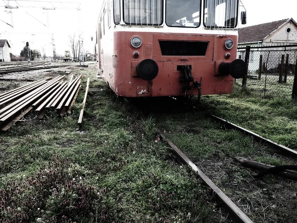 Carro treno retrò di colore rosso. Locomotiva vintage prodotta in Jugoslavia. Sremska Mitrovica, Serbia. Il corpo metallico di un veicolo ferroviario. Rotaie arrugginite. Stazione ferroviaria. Carrozza vuota in un vicolo cieco — Foto Stock