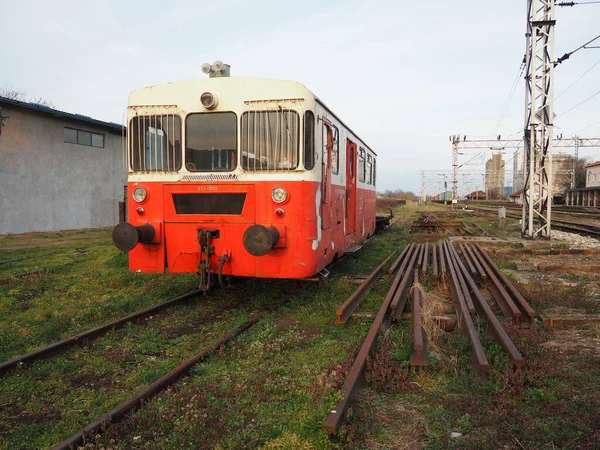 Carro treno retrò di colore rosso. Locomotiva vintage prodotta in Jugoslavia. Sremska Mitrovica, Serbia. Il corpo metallico di un veicolo ferroviario. Rotaie arrugginite. Stazione ferroviaria. Carrozza vuota in un vicolo cieco — Foto Stock