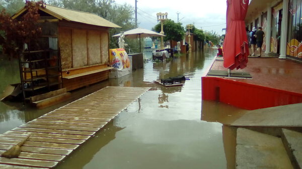 Anapa, Russia August 13, 2021 Flooding caused by heavy rains and downpours. Consequences of a typhoon, cyclone or hurricane. Shopping street flooded with dirty water. Wet belongings and beach walkways