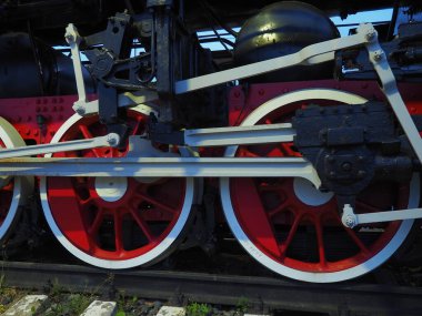 Bir lokomotifin antika tekerlekleri ya da tren yakın çekim. Piston güdümlü kırmızı büyük metal tekerlekler. 19. ve 20. yüzyılların lokomotifi..