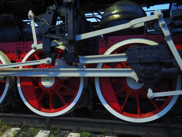 機関車や列車のレトロなヴィンテージホイールを閉じます。ピストンガイド機構を備えた赤い大きな重金属ホイール。蒸気機関車で19～20世紀の機関車. — ストック写真