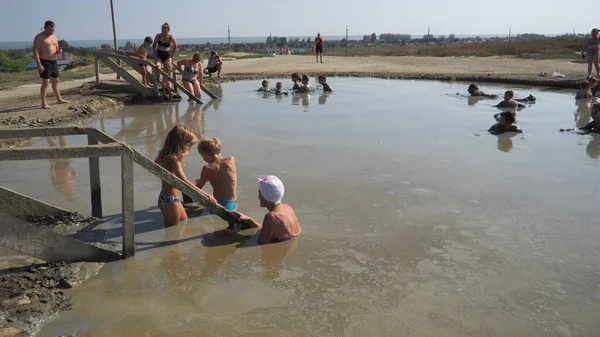 Anapa Russie 28 août 2021 Boue de colline, un produit de l'éruption de volcans de boue. Cratère volcan, volcan de boue Hephaestus. Les gens se baignent et s'amusent dans de l'argile liquide et épaisse. Hommes et femmes diffamés — Photo