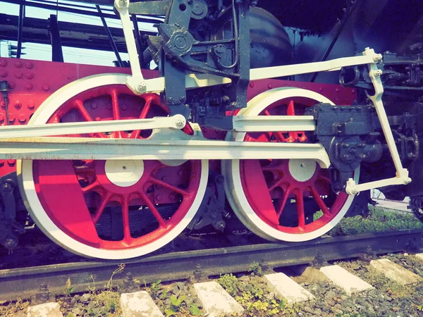 Retro vintage kola lokomotivy nebo vlaku zblízka. Červená velká těžká kovová kola s pístovým naváděcím mechanismem. Lokomotiva 19. až 20. století s parním strojem. Retro styl — Stock fotografie