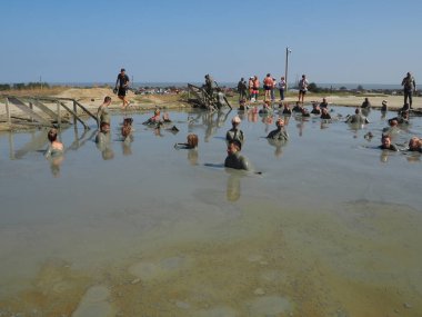 Anapa Rusya 28 Ağustos 2021 Hill çamuru, çamur volkanlarının patlamasının bir ürünü. Volkan krateri, Hephaestus çamur volkanı. İnsanlar sıvı, kalın çamurda banyo yapar ve keyif alırlar. Erkekler ve kadınlar lekelenmiş