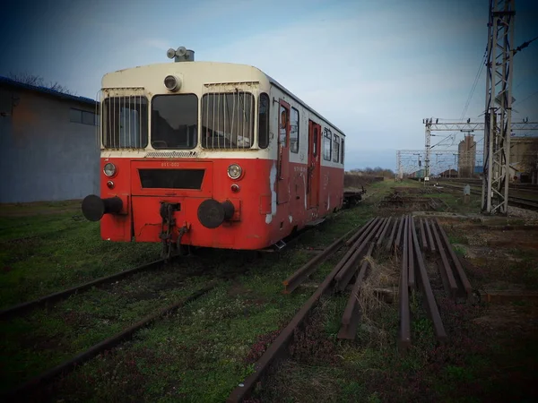 赤い色のレトロな列車ワゴン。ユーゴスラビア製のヴィンテージ機関車。セルビアのスレムスカ・ミトロヴィツァ。鉄道車両の金属製ボディ。錆びた鉄道駅。行き止まりで空の馬車。ヴィネット — ストック写真