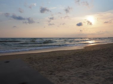 Denizin üzerinde gün batımı. Gün batımında güzel dalgalar. Turist Mekke, tatil köyü. Akşam gökyüzü. Işınlar sudan yansıyor..