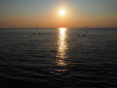 Anapa, Rusya 23 Ağustos 2021 Deniz üzerinde Gün Batımı. Gün batımında güzel dalgalar. Turist Mekke, tatil köyü. Akşam gökyüzü. Işınlar sudan yansıyor. Gemiler ve insanlar denizde yüzüyor.