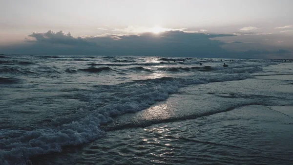 浪花与泡沫。美丽的日落浪花在沙滩上翻滚.Vityazevo，Anapa，黑海。旅游胜地梅卡，健康胜地。夜空中的彩云.光线反射出水面 — 图库照片