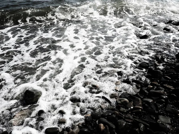 Sea rocky beach with waves, Sukko, Anapa, Krasnodar Territory, Russia. Sea foam on a pebble beach view from above. Large rounded pebbles and boulders in the water. Horizontal photo Black Sea, Caucasus — Stock Photo, Image