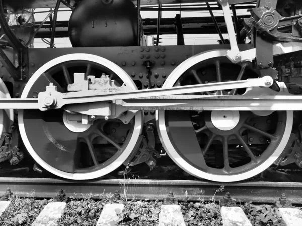 Retro train two wheels. Sleepers and rails, mechanisms, pistons and guides. Locomotive of the 19th early 20th century with a steam engine. Vintage style. Black - white photo. Beautiful card.