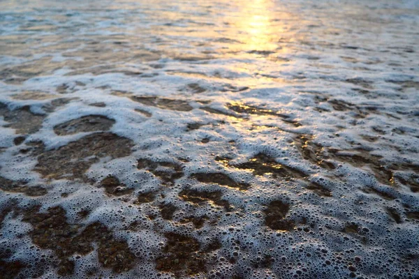Ola y puesta de sol sobre el mar. Hermoso atardecer. Olas espumosas rodan sobre la orilla arenosa. Vityazevo, Anapa, Mar Negro. Lugar turístico, centro de salud. Cielo nocturno. Los rayos se reflejan en el agua —  Fotos de Stock
