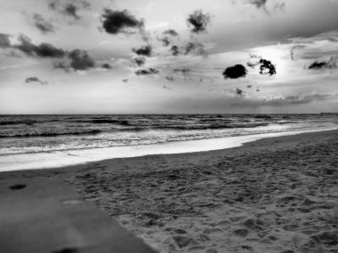 Denizin üzerinde gün batımı. Gün batımında güzel dalgalar. Turist Mekke, tatil köyü. Akşam gökyüzü. Işınlar sudan yansıyor..