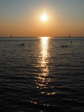 Anapa, Rusya 23 Ağustos 2021 Deniz üzerinde Gün Batımı. Gün batımında güzel dalgalar. Turist Mekke, tatil köyü. Akşam gökyüzü. Işınlar sudan yansıyor. Gemiler ve insanlar denizde yüzüyor.