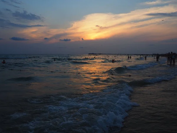 Puesta de sol sobre el mar. Hermosas olas al atardecer. Meca turística, resort. Cielo nocturno. Los rayos se reflejan desde el agua. — Foto de Stock