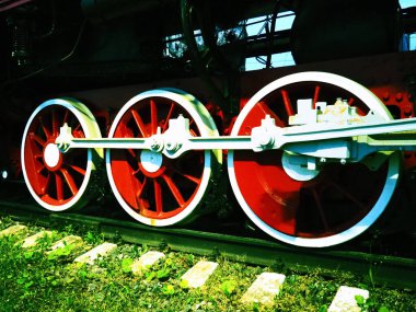 Bir lokomotifin antika tekerlekleri ya da tren yakın çekim. Piston güdümlü kırmızı büyük metal tekerlekler. Buhar makinesiyle 19.-20. yüzyılın lokomotifi. Parlak canlı fotoğraf