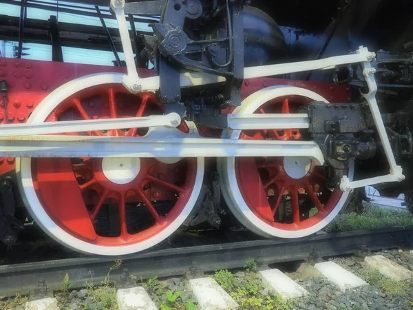 Retro vintage koła lokomotywy lub pociągu zbliżenie. Czerwone duże metalowe koła z mechanizmami tłokowymi. Lokomotywa 19 - 20 stulecie z parowóz. Zamazane miękkie skupienie — Zdjęcie stockowe