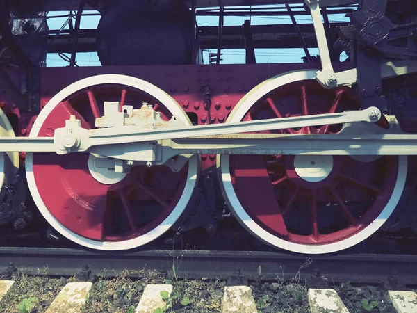 Ruote retrò vintage di una locomotiva o treno da vicino. Grandi ruote rosse in metallo pesante con meccanismi di guida a pistone. Locomotiva del XIX-XX secolo con motore a vapore. Stile retrò. — Foto Stock