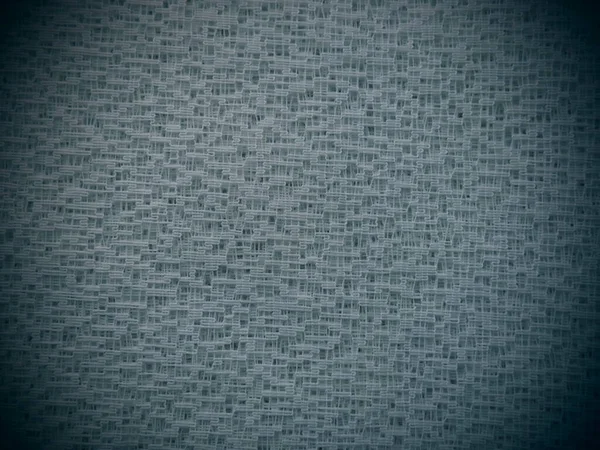 Sheer gray net-like tulle. Mesh fabric. Close-up. Grey veil or muslin. Close-up of a curtain with holes of different sizes. Dark vignetting around the edges — Stock Photo, Image