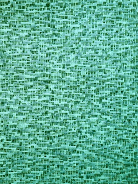 Sheer green net-like tulle. Mesh fabric. Close-up. Veil or muslin. Close-up of a curtain with different sized holes. Abstract background