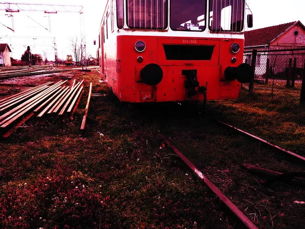 Carro treno retrò di colore rosso. Locomotiva vintage prodotta in Jugoslavia. Sremska Mitrovica, Serbia. Il corpo metallico di un veicolo ferroviario. Rotaie arrugginite. Stazione ferroviaria. Carrozza vuota in un vicolo cieco — Foto Stock