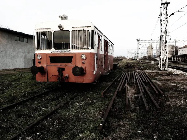 Carro treno retrò di colore rosso. Locomotiva vintage prodotta in Jugoslavia. Sremska Mitrovica, Serbia. Il corpo metallico di un veicolo ferroviario. Rotaie arrugginite. Stazione ferroviaria. Carrozza vuota in un vicolo cieco — Foto Stock