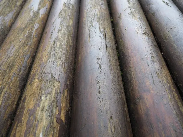 Un tronco de construcción para su uso en construcción sin aserrado longitudinal. Surtido de madera redonda. Fragmento de la construcción de troncos de madera redondeados. El efecto de la humedad en la madera . —  Fotos de Stock