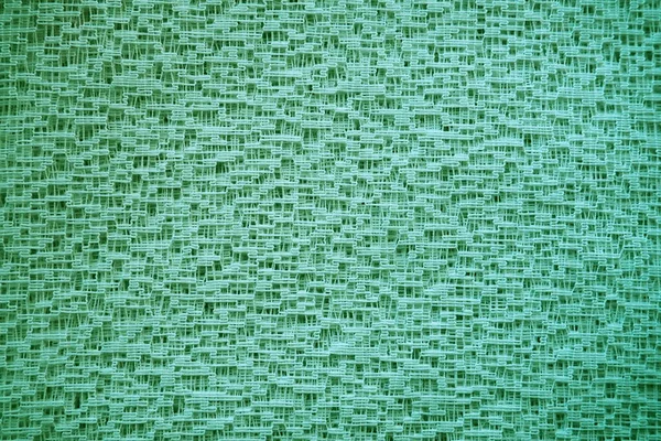 Sheer green net-like tulle. Mesh fabric. Close-up. Veil or muslin. Close-up of a curtain with different sized holes. Abstract background