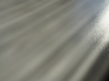 Soyut gri arkaplan. Gri arkaplanda belirsiz ışık huzmeleri ve titreşen noktalar. Sağ üstten, çizgiler aşağı ve sola doğru. Parla, parla ya da parla. Yan ışıklandırma. Küçük bir parıltı