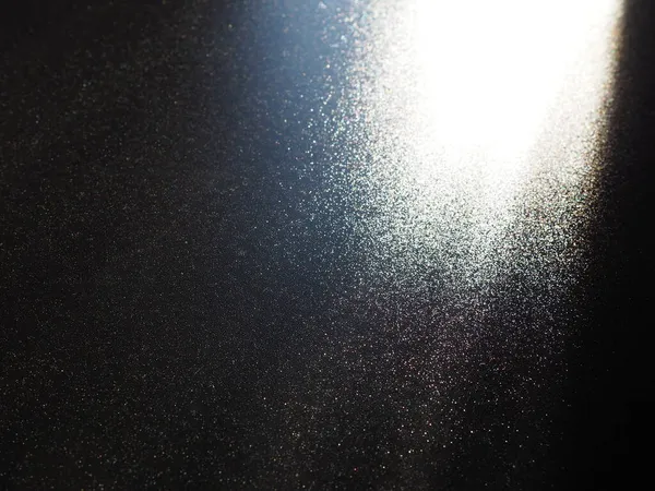 Absztrakt fekete háttér. Oblique fénysugarak egy fekete feketepiacon villogó pontokkal. Jobbról fentről lefelé és balra irányulnak a vonalak. Ragyogj, ragyogj vagy ragyogj. Oldalsó világítás. Kis fényesség — Stock Fotó