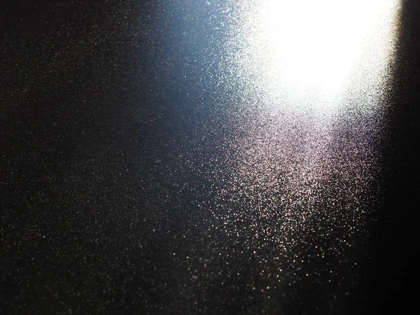 Absztrakt fekete háttér. Oblique fénysugarak egy fekete feketepiacon villogó pontokkal. Jobbról fentről lefelé és balra irányulnak a vonalak. Ragyogj, ragyogj vagy ragyogj. Oldalsó világítás. Kis fényesség — Stock Fotó