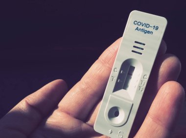 COVID-19 için test sonuçları negatif, enfeksiyon değil, hızlı test ekipmanları kullanılarak. Elinde koronavirüs testi, koyu arkaplan. Uzayı kopyala Konsept Coronavirus Hastalığı Testi.