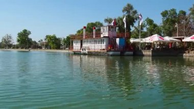 Palich Gölü, Sırbistan, 09.11.2021. Gün boyunca gölün kıyısındaki kafeler ve restoranlar. Gemi restoranı. Turistlerle dolu bir tekne. İnsanlar rahatlatıcı. Sudaki dalgalanmalar. Güneşli
