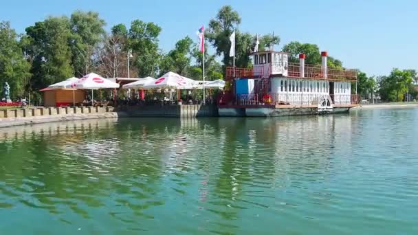 Palich Lake Serbia 2021 水库岸边的咖啡店和餐馆 船务餐厅与游客同行的愉快船 人们都在放松 水面上的波纹 — 图库视频影像