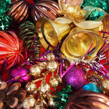 Noel süslemeleri, tatil baloları, çanlar, yaylar, köknar konisi, Noel ağacı yağmuru. Mutlu yıllar ve mutlu Noeller. Kırmızı, kahverengi, çizgili, yeşil, altın, mor, renkli dekor