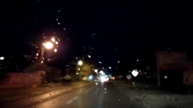 Geceleri trafik vardı. Arabanın ön camında yağmur damlaları var. Asfalt yolu ya da patika. Bulanık ve odaksız etki. Camdaki damlacıklara odaklan. Gece lambaları, arabalar, yol işaretleri. Sırbistan, Srem