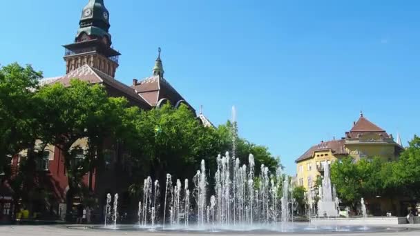 Subotica, Serbia, 12 de septiembre de 2021. Fuente en la plaza de Subotica entre el Ayuntamiento, el edificio del Teatro Nacional y la Biblioteca de la Ciudad. Jets de agua limpia, salpicaduras y gotas. — Vídeos de Stock