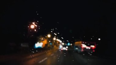 Gece araba sürüyorum. Arabanın ön camında yağmur damlaları var. Asfalt yolu ya da patika. Bulanık ve odaksız etki. Damlalara odaklan. Gece lambaları, kamyonlar, arabalar, yol işaretleri. Araba dönüyor.