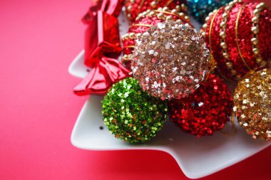 Noel süslemeleri, tatil baloları, çanlar, yaylar, köknar konisi, Noel ağacı yağmuru. Mutlu yıllar ve mutlu Noeller. Kırmızı, kahverengi, çizgili, yeşil, altın, mor, renkli dekor