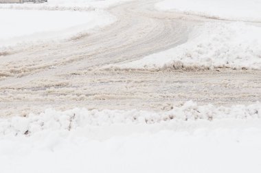 Bir çatal ya da kavşağın yan tarafı. Yolun kenarında kar yağışı var. Kötü hava ve trafik. Asfaltta kar var. Zorlu sürüş koşulları. Otomatik yolda kış çamuru