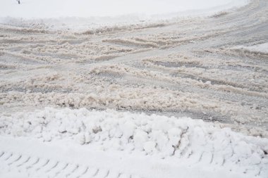 Bir çatal ya da kavşağın yan tarafı. Yolun kenarında kar yağışı var. Kötü hava ve trafik. Asfaltta kar var. Zorlu sürüş koşulları. Otomatik yolda kış çamuru