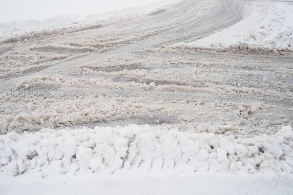 叉子从回旋处伸出的叉子或侧边路边的雪地在飘扬 恶劣的天气和交通 柏油路上的雪困难的驾驶条件 车路上的冬季雨雪 — 图库照片