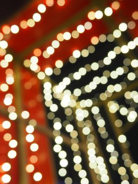 Noel gecesi Bokeh. Güzel yuvarlak bokeh röfleleri. Kırmızı, sarı, altın, karanlıkta beyaz renkler. Yeni yıl için şenlikli bir geçmiş. Mutlu Noeller. Bulanık defocus. Şehir sokaklarının dekorasyonu