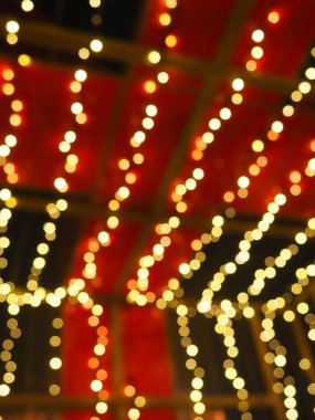 Noel gecesi Bokeh. Güzel yuvarlak bokeh röfleleri. Kırmızı, sarı, altın, karanlıkta beyaz renkler. Yeni yıl için şenlikli bir geçmiş. Mutlu Noeller. Bulanık defocus. Şehir sokaklarının dekorasyonu