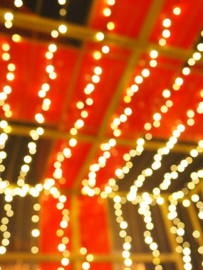 Noel gecesi Bokeh. Güzel yuvarlak bokeh röfleleri. Kırmızı, sarı, altın, karanlıkta beyaz renkler. Yeni yıl için şenlikli bir geçmiş. Mutlu Noeller. Bulanık defocus. Şehir sokaklarının dekorasyonu