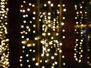 Noel gecesi Bokeh. Güzel yuvarlak bokeh röfleleri. Kırmızı, sarı, altın, karanlıkta beyaz renkler. Yeni yıl için şenlikli bir geçmiş. Mutlu Noeller. Bulanık defocus. Şehir sokaklarının dekorasyonu