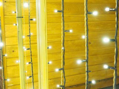 Noel gecesi dekoratif çelenkler. Güzel yuvarlak bokeh röfleleri. Sarı arka planda beyaz ışıklar. Yeni yıl için şenlikli zemin Mutlu Noeller