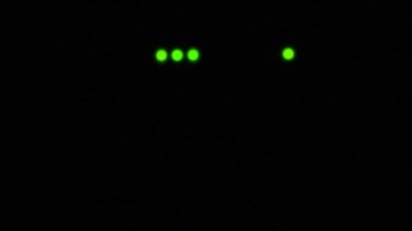 Wi-Fi yönlendirici ya da modem ışığı yanıp sönüyor. Kablosuz internet bağlantısı. Siyah karanlıkta yanıp sönen yeşil uyarı ışıkları. Bilgiyi modern iletişim araçlarıyla aktarma süreci.